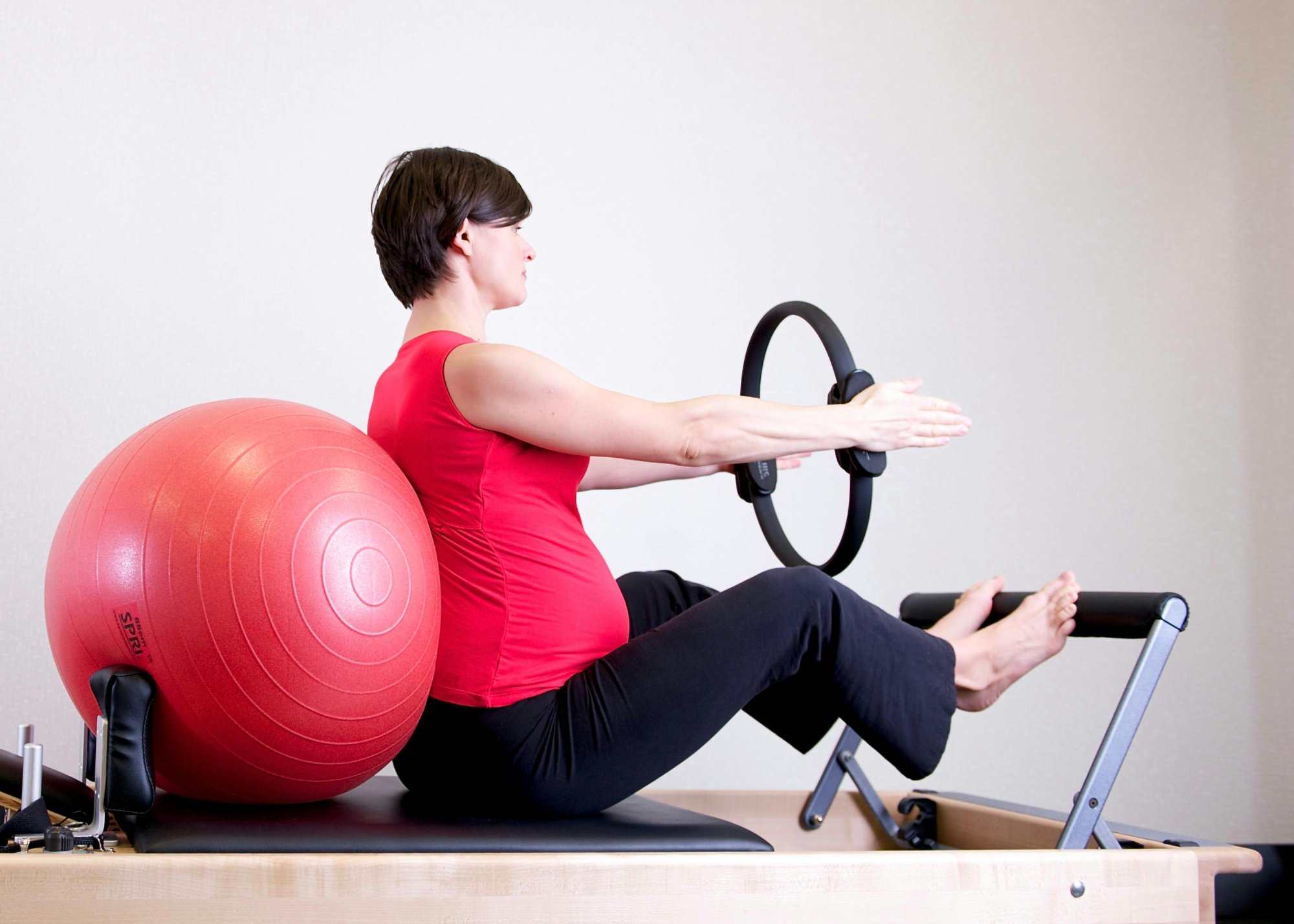 Woman practicing Pilates with magic circle on reformer