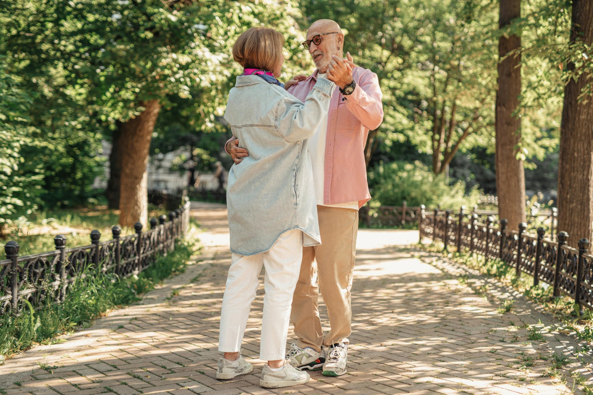 Older couple dancing outdoors in a park